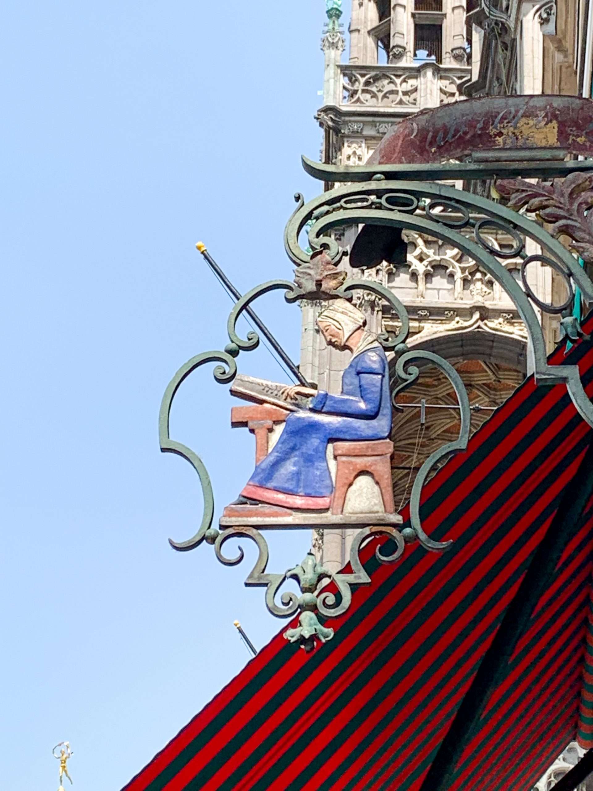 Image shows an old iron street sign located above a building in Brussels, be sure yo look up when visiting Brussels for a day!