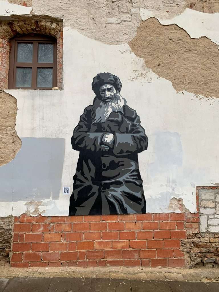Image shows some street art in the Jewish Quarter of Vilnius. The art depicts a Jewish man residing in Vilnius old town before WW2