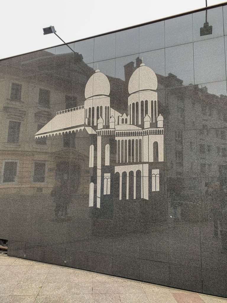 An image of a destroyed synagogue is etched into the marble exterior of the building that replaced it as a memorial.