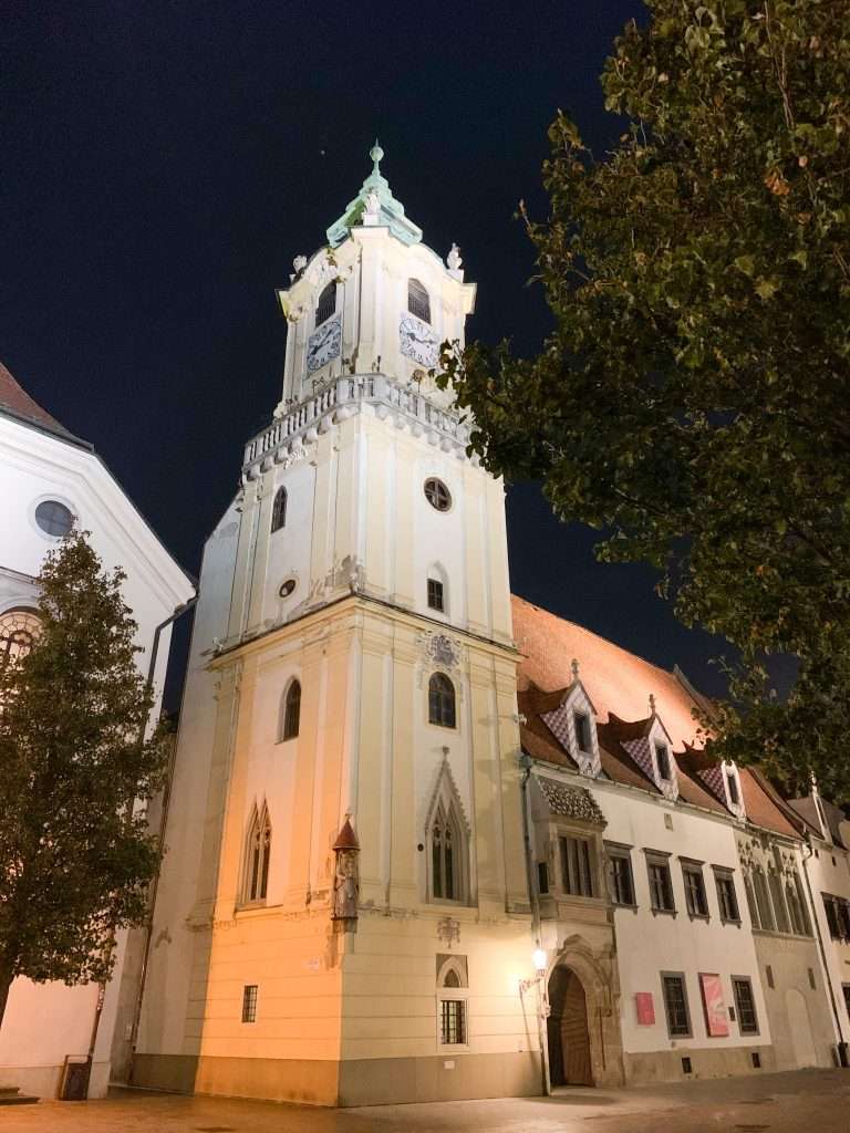 A view of the tower forming part of the Old Town Hall in Bratislava as seen in the evening. The tower is lit with spotlights.