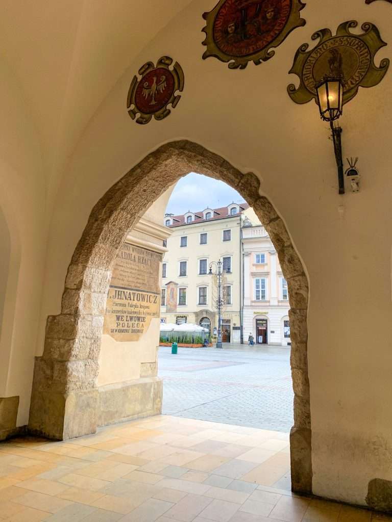 Image shows the view looking out form the Cloth Hall, one of the best things to see in Krakow!