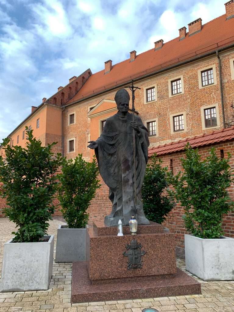 Image shows a statue of John Paul II at Wawel Cathedral