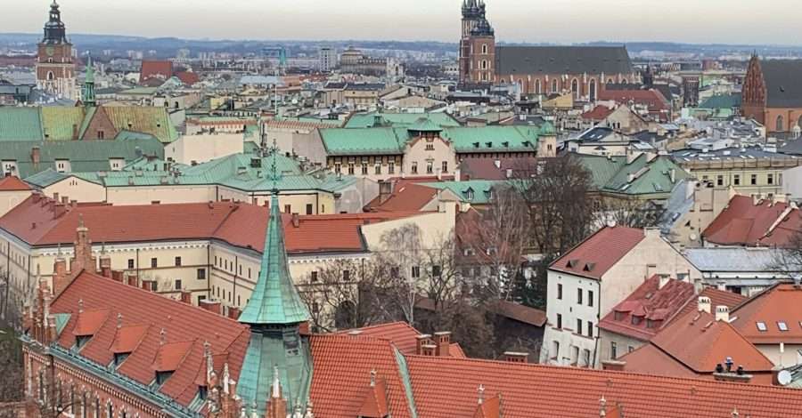 The view over the terracotta roofs of Krakow Old Town. Several church spires are also visible.