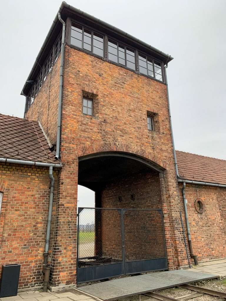 Image shows the unforgettable Gates of Hell into Auschwitz II