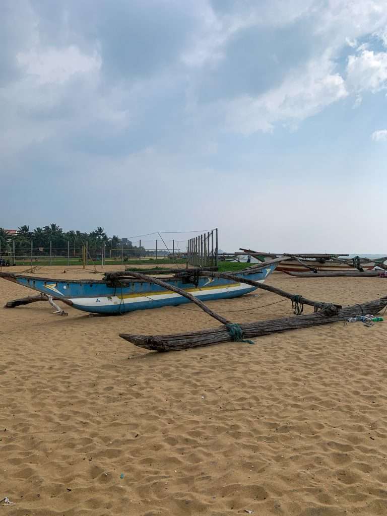 Image shows traditional boats on the beach in Negombo, one of the best places to visit in Sri Lanka 