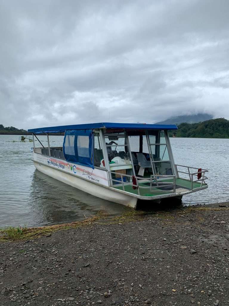 Image shows a boat on the banks of Arenal Lake that will ferry visitors across the lake to Monteverde in Costa Rica.