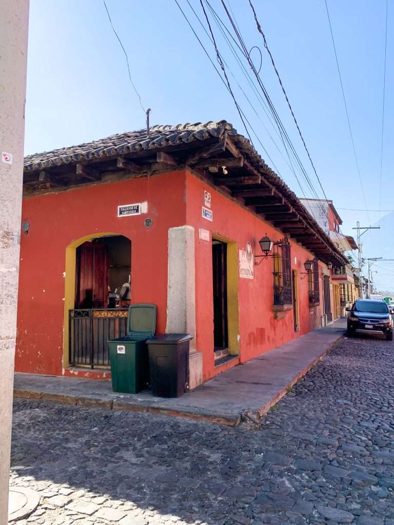 Images shows a colourful Colonial building seen during a day in Antigua