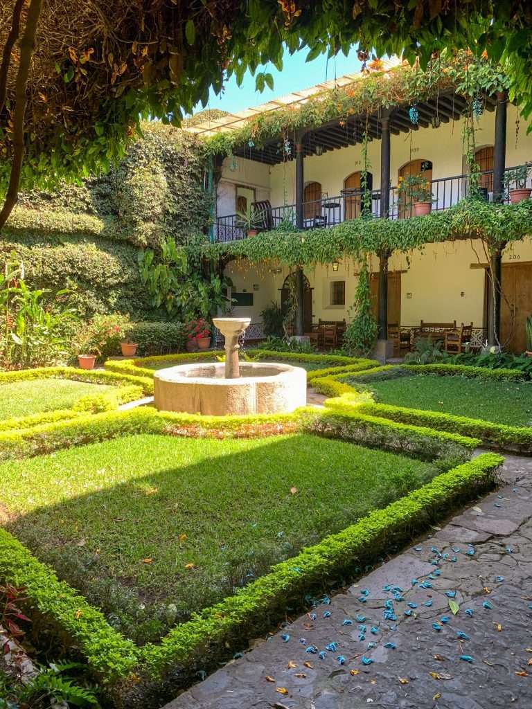 Image shows a scene in a small garden courtyard. The image was captured during a walking tour of Antigua Guatemala, a great way to spend time in Antigua.