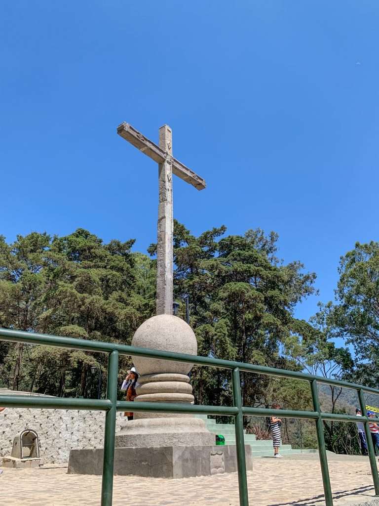 Image shows The Cross on the Hill in Antigua. Hiking up to the Cross is one of the best things to do during a day in Antigua Guatemala.