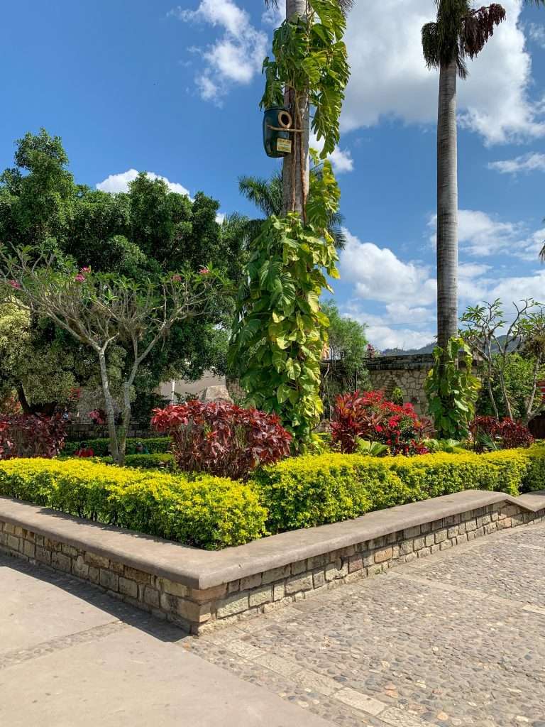 Image shows a view of Parque Central in Copan Ruinas, Honduras. Relaxing and people watching in Central Park is one of the best things to do when visiting Copán