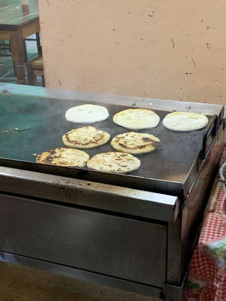 Pupusas cooking on an outdoor grill. Eating Pupusas is definitely one of the things to do in Suchitoto!
