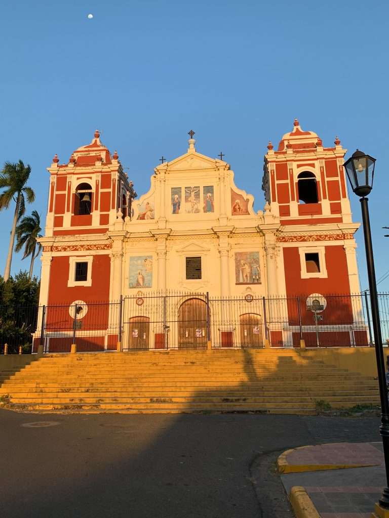 Image shows the El Cavario church, a terracotta red and yellowish coloured in León Nicaragua.