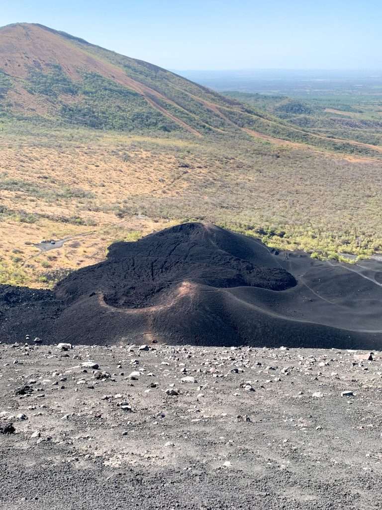 The view from Cerro Negro before boarding down it. Black sandy gravel is visible in the image.