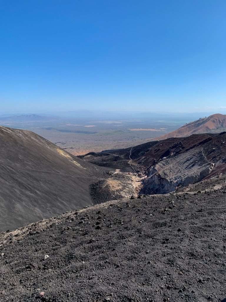 A view from Cerro Negro before boarding down it. Black sandy gravel is visible in the image.