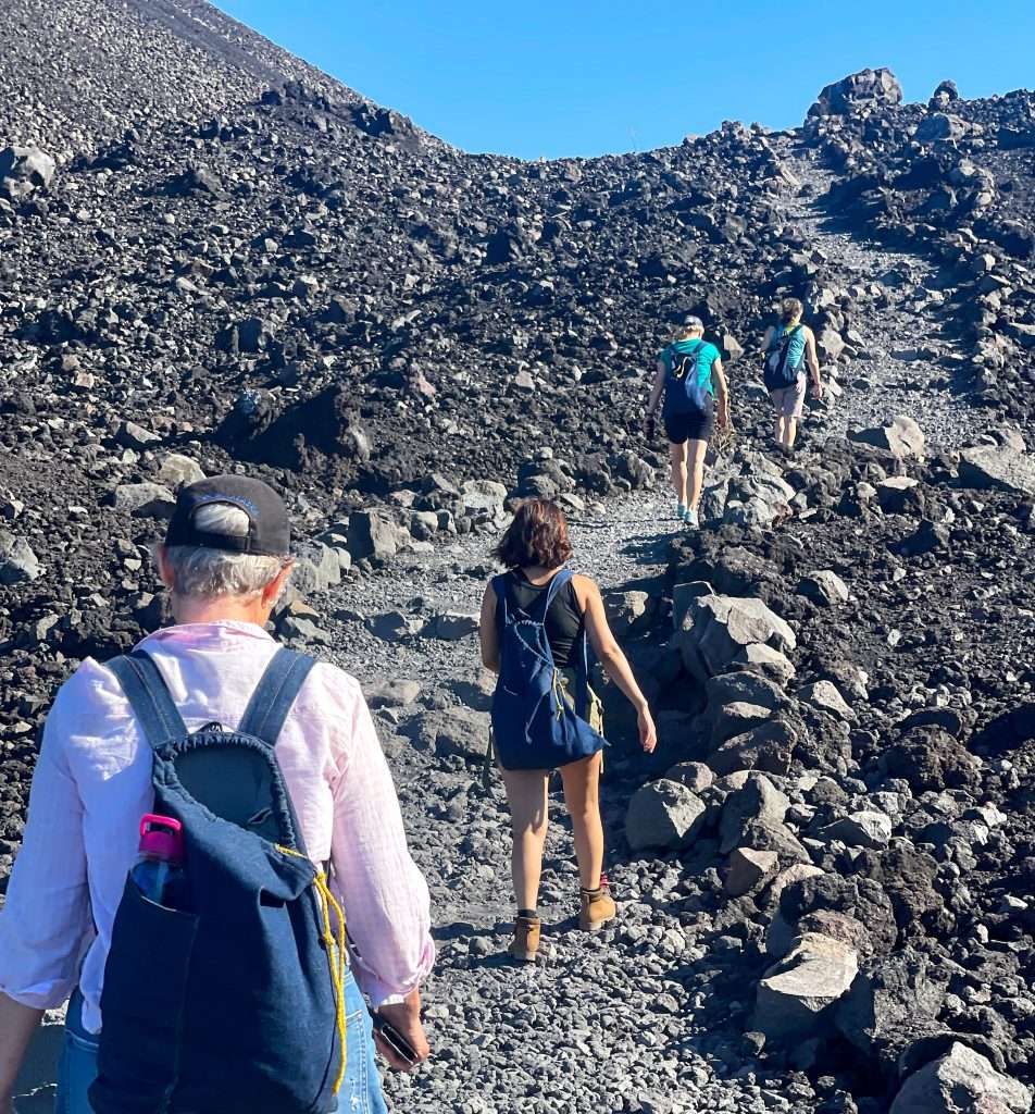 Sarah, the author of this blog post, and others hiking up Cerro Negro, an active volcano in Nicaragua, before experiencing the thrill of boarding down it.