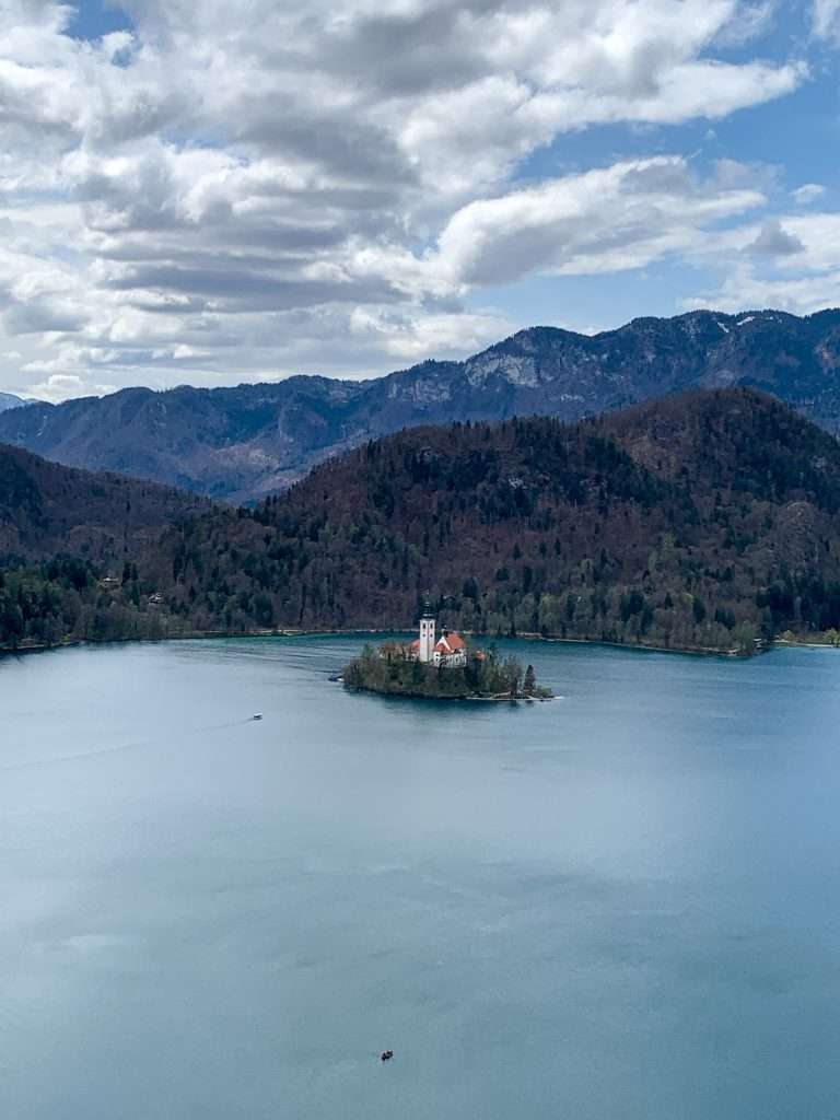 A view of Bled Island as seen from Bled Castle. The church and tower are visible however they appear small as the image was captured from the Castle which is some distance from the middle of the Lake where Bled Island is located.