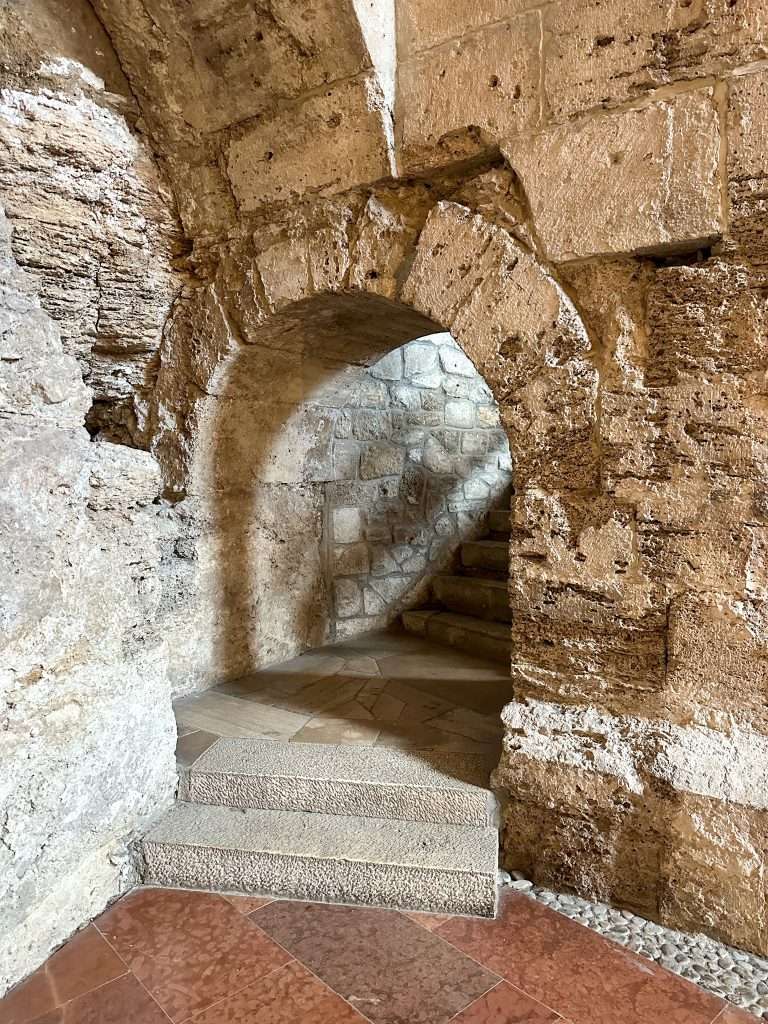A view of an archway through which can be seen stone steps. 