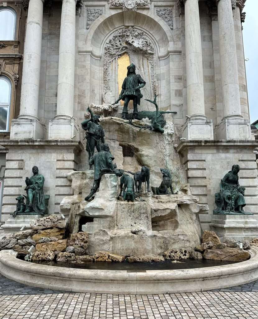 The Mátyás Fountain in Budapest featuring multiple characters in bronze.