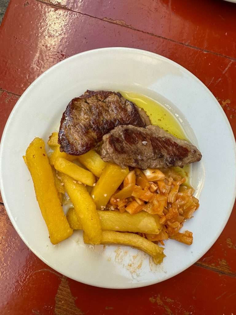Image shows a plate of sirloin in a whiskey sauce, part of a tapas selection. Eating tapas is one of the best things to do in Seville. 