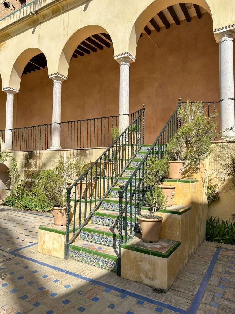 Image shows a stairway down to a courtyard garden within the grounds of the Royal Alcázar