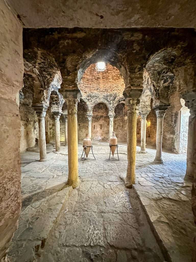 A view of the Arab Baths with ancient pillars holding up arched ceilings