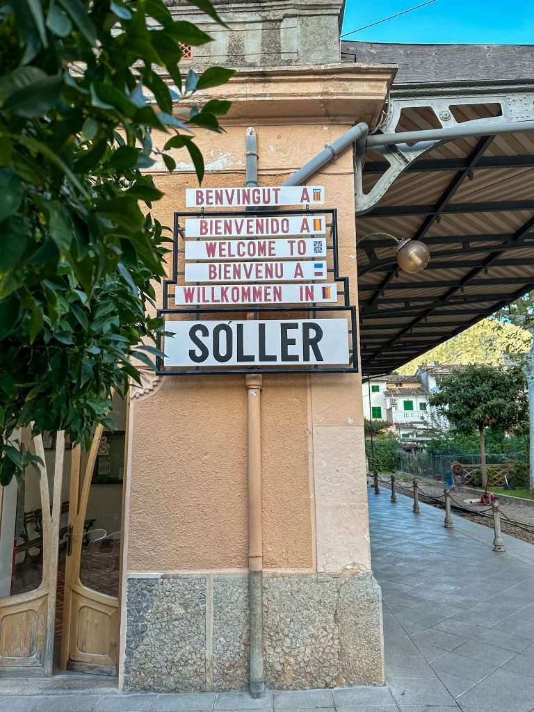 The signage at Soller train station welcomes visitors to Soller in various languages including English