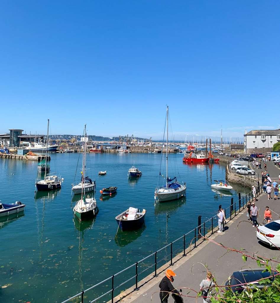 Brixham harbour with boats bobbing in the sea. A day trip to Brixham is one of the things to do during a holiday in Torquay