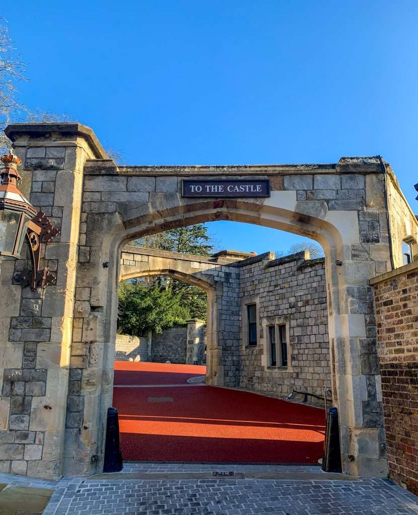 A stone arch through which visitors to Windsor Castle pass after purchasing their tickets and before entering the Castle grounds. A sign above the gate reads "To the Castle".