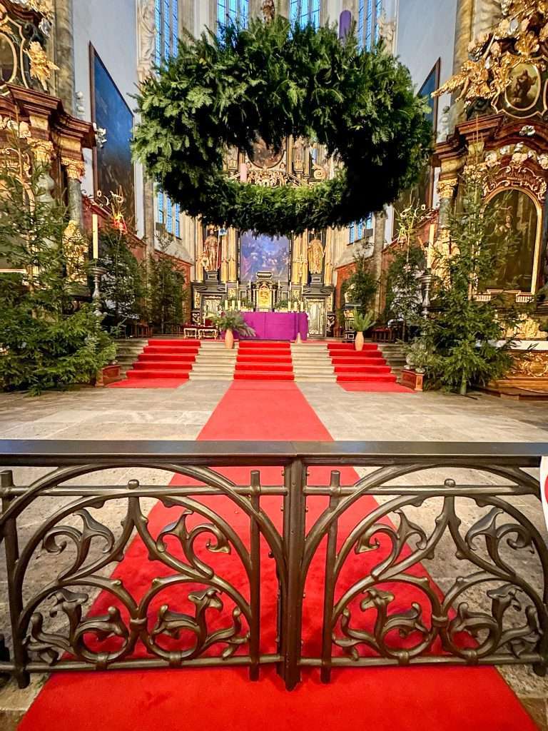 A view of some of the internal areas of the church of Our Lady before Tyn in Prague, including red carpeting near the alter.