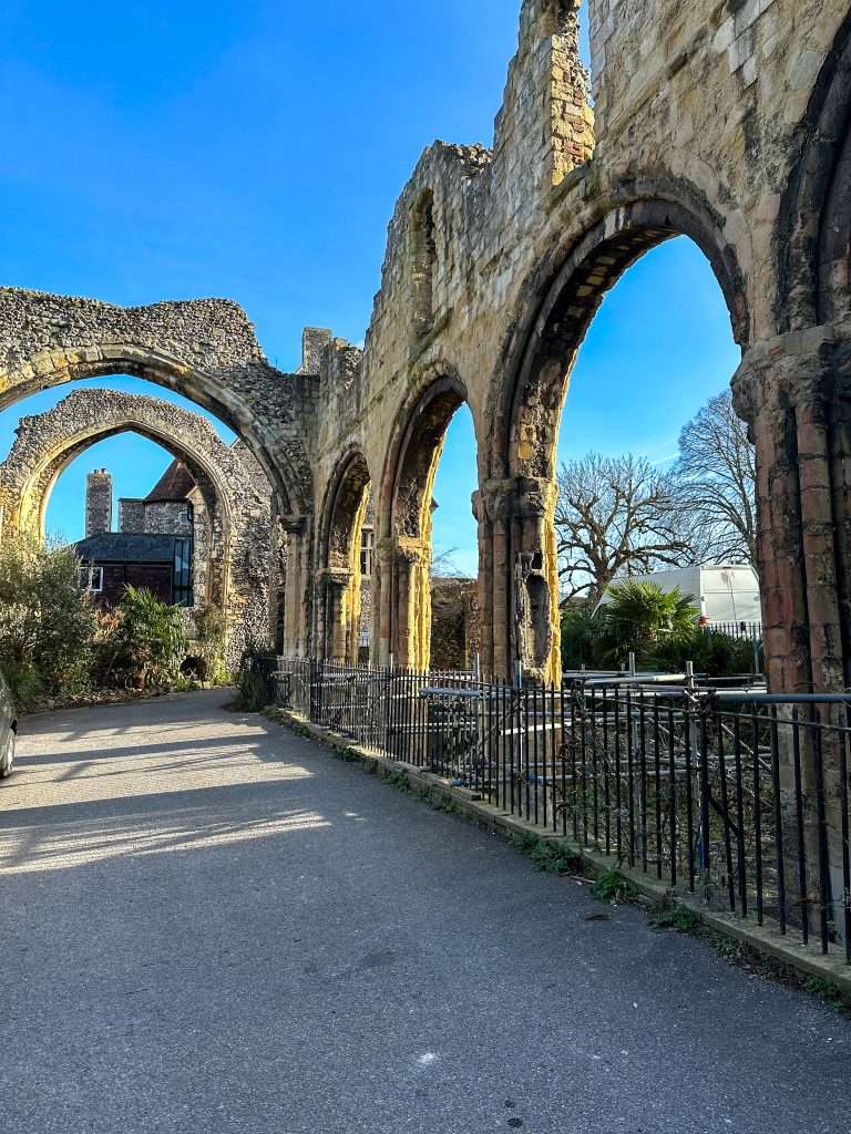 Ruins of the Monk's Infirmary remain at Canterbury Cathedral. Stone archways and partial surrounds are still standing.