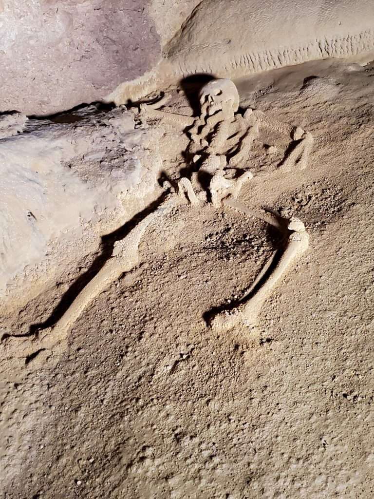 Image shows a skeleton located within the ATM Cave. An exploration of the cave is a must do as part of a Belize travel itinerary.