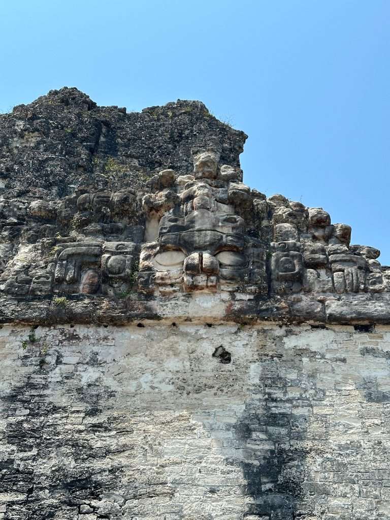 Image shows a carved mask on Temple II at Tikal.