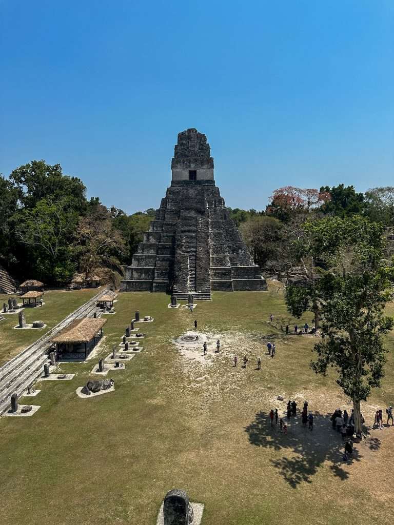 Image shows the Great Plaza at the Mayan Ruins of Tikal. The image is taken from high up on Temple II looking down onto the Great Plaza.