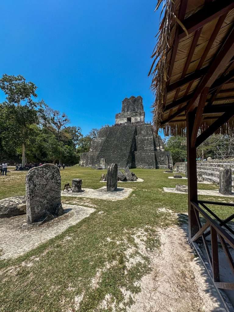 Image is taken at ground level and shows Temple II at the Tikal Mayan Ruins in Guatemala. 