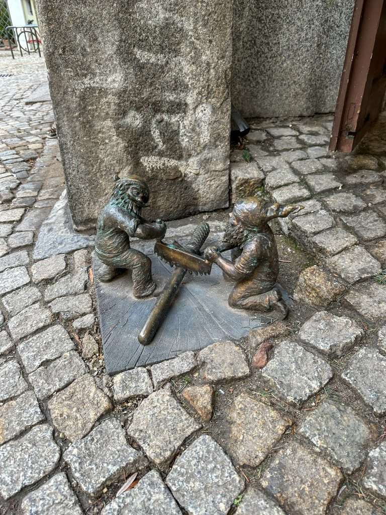 Image shows a dwarf statue in Wroclaw called the Stripling and the Rioter. Hunting down some of the over 1000 dwarfs is one of the best things to do in Wroclaw!