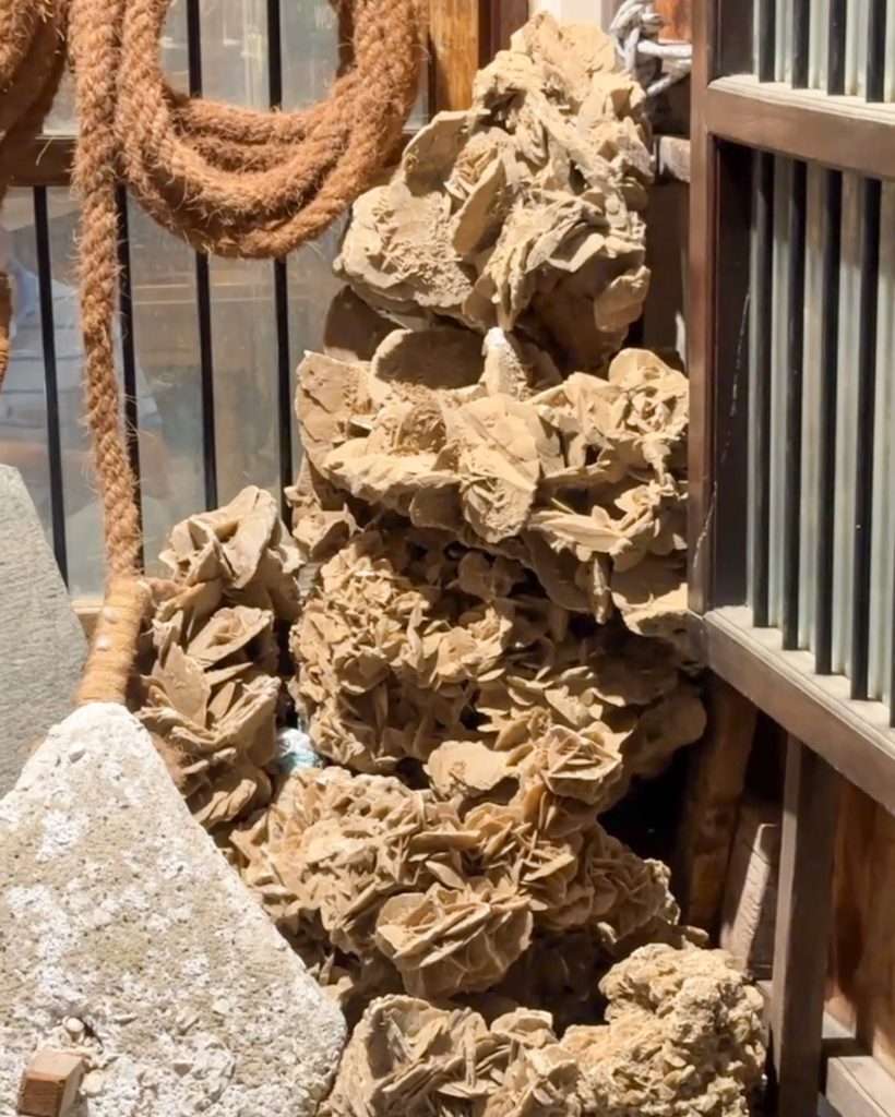 A collection of light brown coloured desert rose crystals. They are also known as sand roses due to being rose shaped.