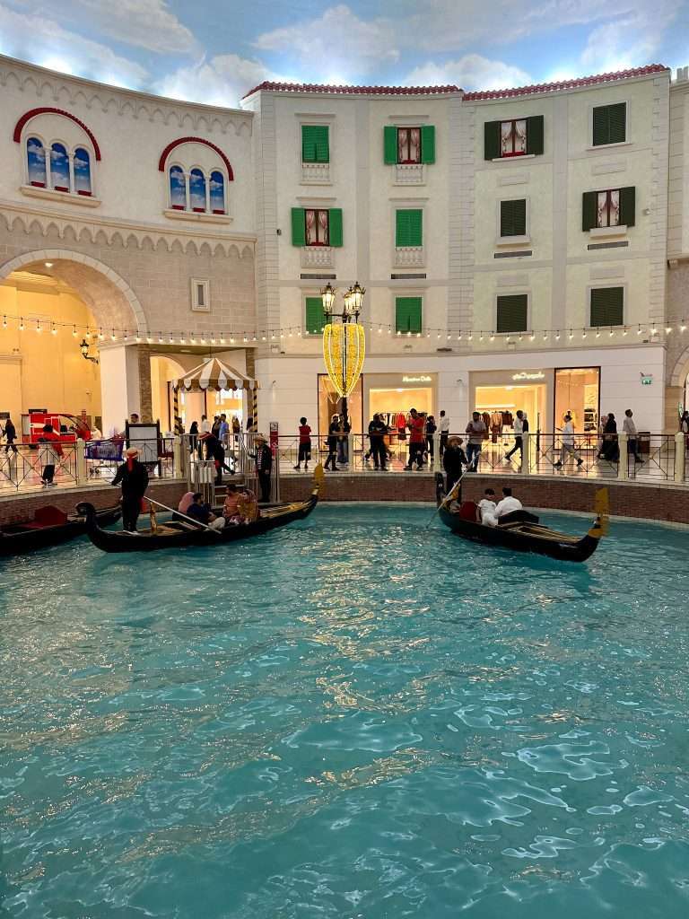 Two gondolas on a fake Venetian canal within the Villaggio Shopping Mall in Doha await passengers.